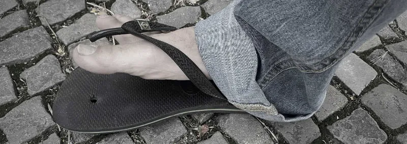 A broken Havaianas flip flop with the strap pulled through the sole